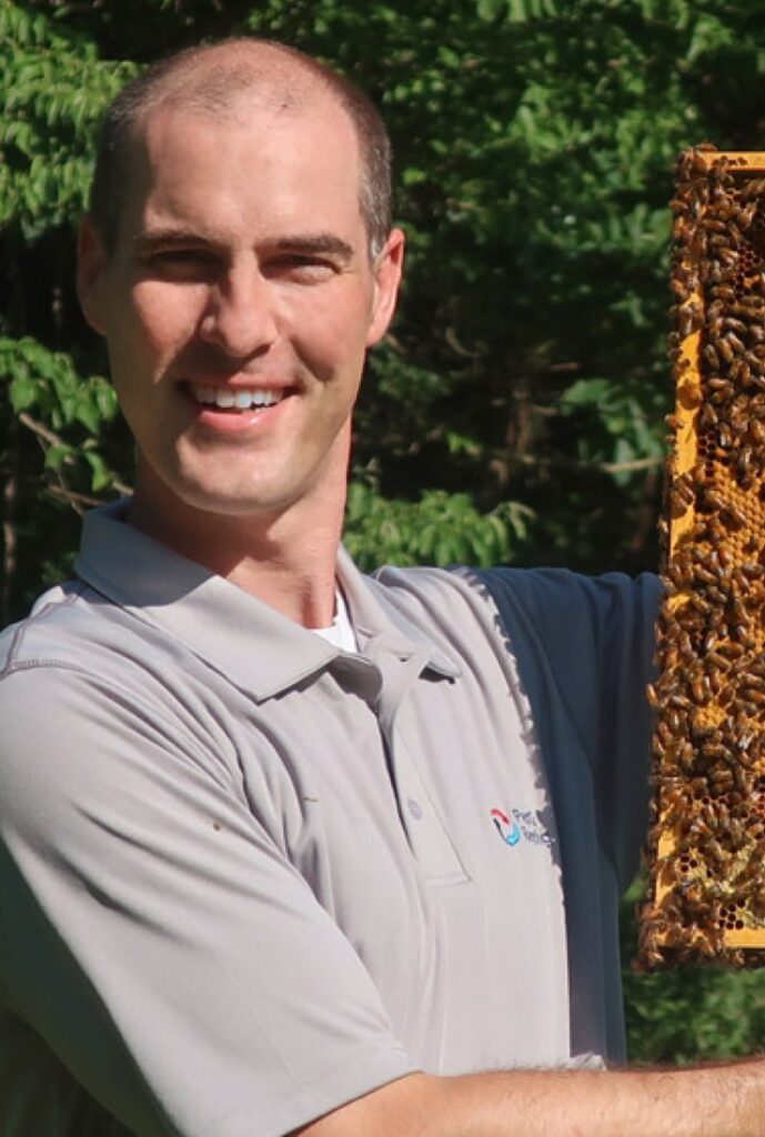 Man holding part of bee hive