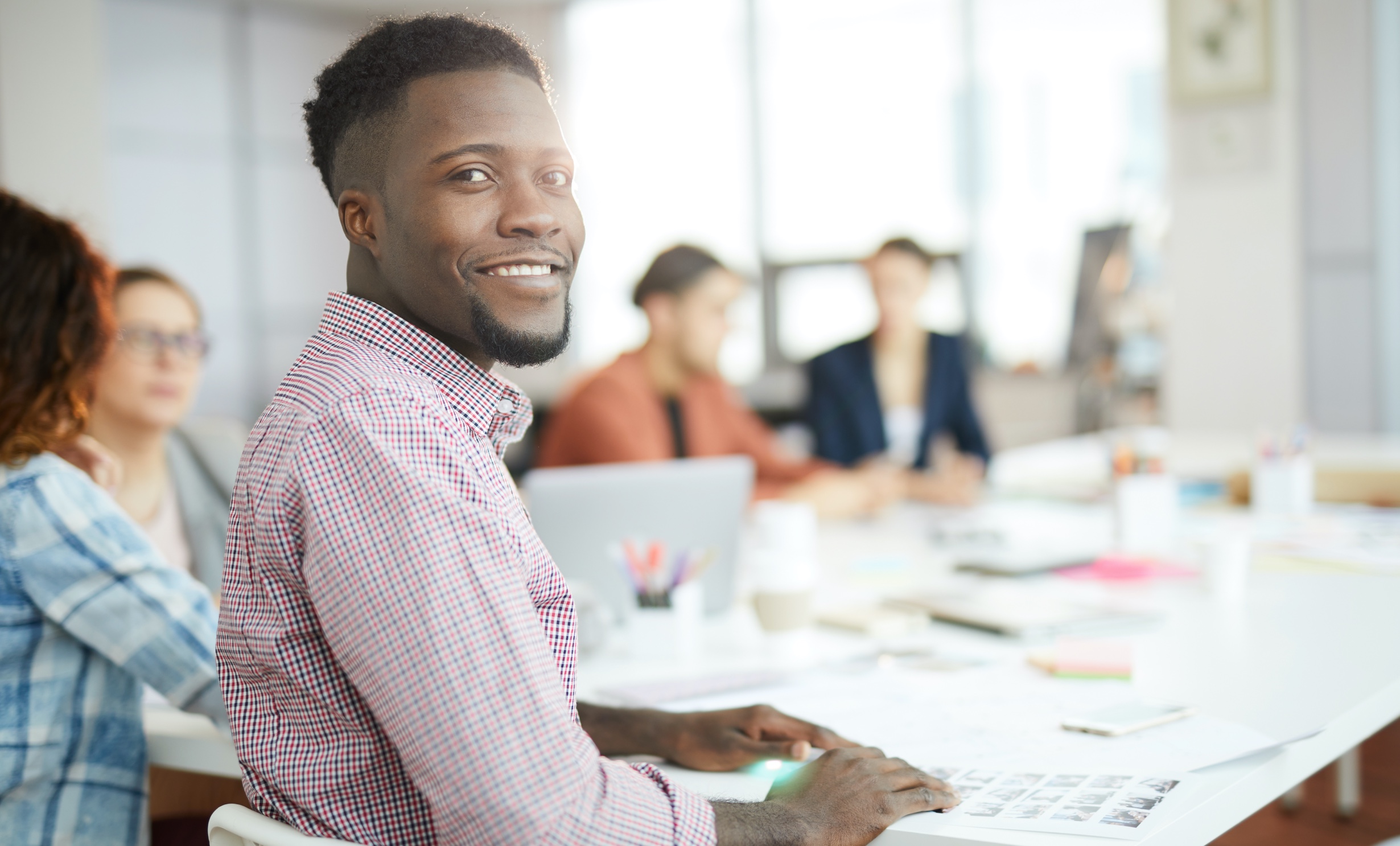 Man sitting at conference table and looking over his shoulder